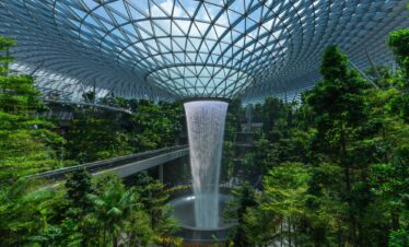 Jewel Changi Airport features a beautiful waterfall nestled in a tropical forest, enhancing the natural beauty of the space.