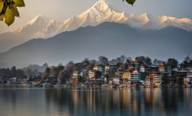 Scenic view of Kathmandu, Nepal, showcasing its vibrant architecture and lush hills under a clear blue sky.