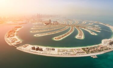 Aerial view of Palm Island in Dubai, showcasing its unique shape and luxury resorts, a popular tourist destination.