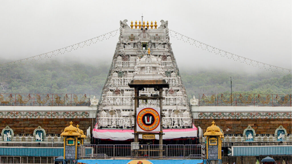 A large white structure, the Tirumala Tirupati Raja Gopuram, featuring elaborate carvings and architectural style.