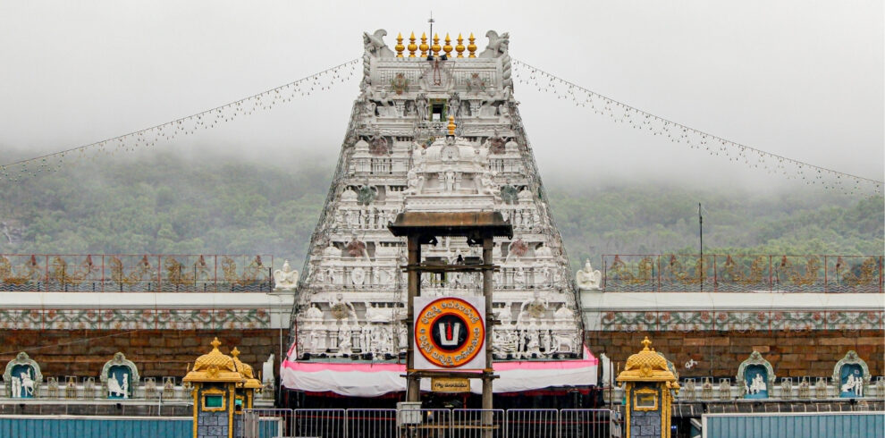 A large white structure, the Tirumala Tirupati Raja Gopuram, featuring elaborate carvings and architectural style.